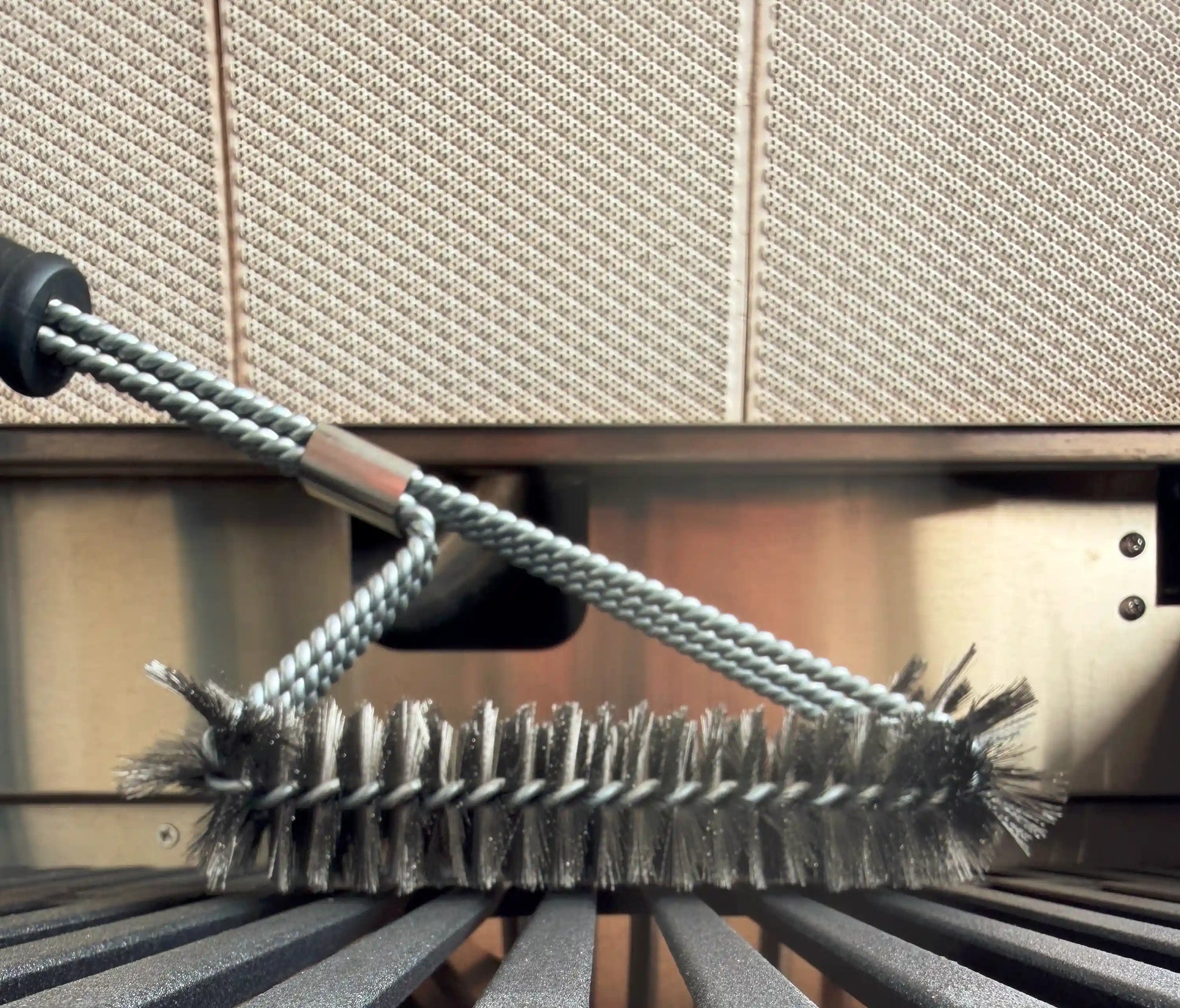 Grillbürste im Grill von der Seite